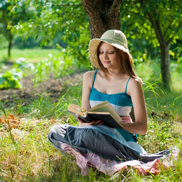 Šťastné dospívající dívka s knihou venku — Stock fotografie