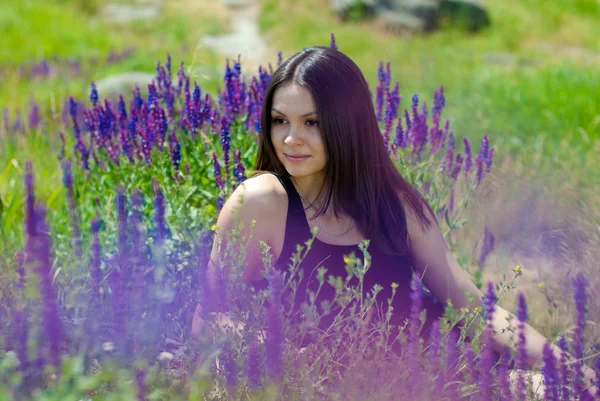 Joven mujer feliz descansando entre flores de campo — Foto de Stock
