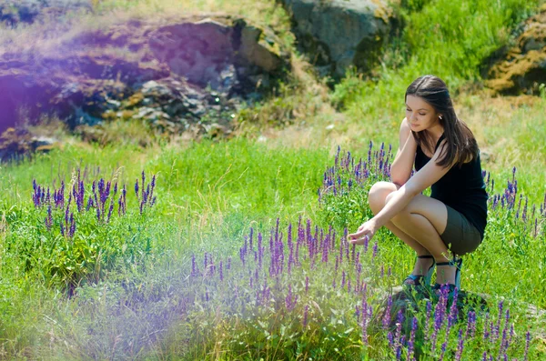Mladá šťastná žena odpočívá mezi pole květy — Stock fotografie