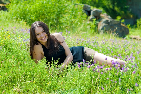 Mutlu kadın alan çiçekler arasında dinleniyor — Stok fotoğraf