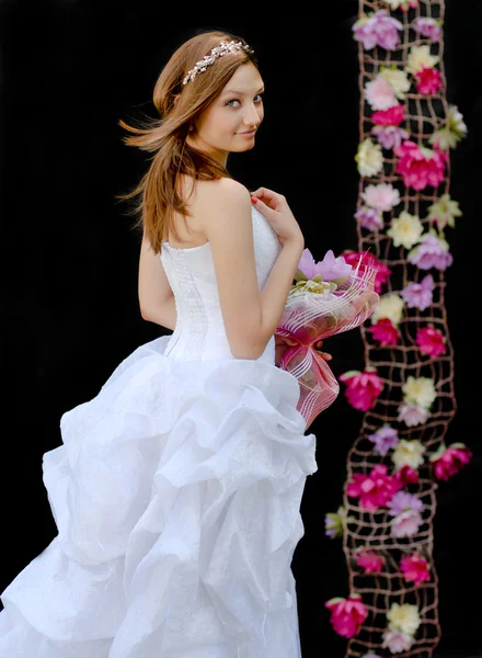 Mladá krásná nevěsta díval přes rameno na černém pozadí — Stock fotografie
