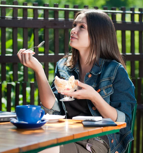 Fiatal gyönyörű nő eszik fagylaltot, kávézó — Stock Fotó