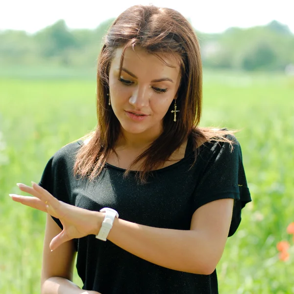 Jovem mulher olhando na mão relógio preocupado — Fotografia de Stock