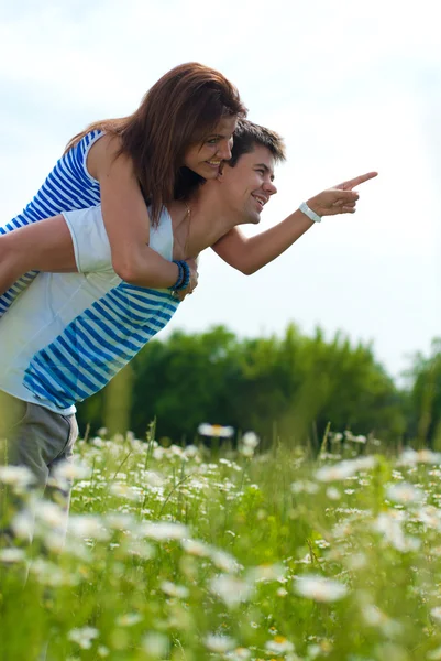 Молодая счастливая пара, стоящая на зеленой траве — стоковое фото