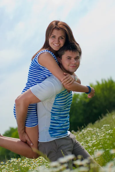 Young happy couple standing on green grass — Stock Photo, Image