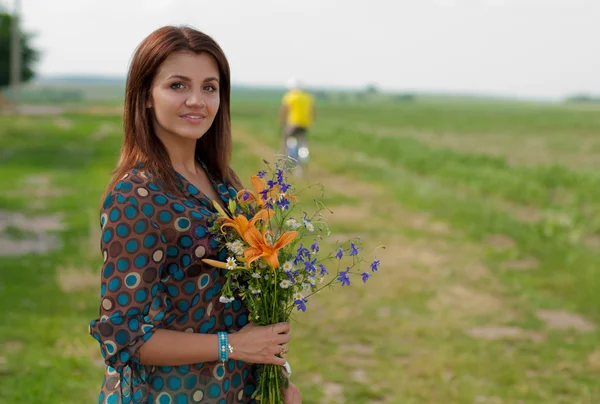 Młoda piękna kobieta z bukiet kwiatów — Zdjęcie stockowe