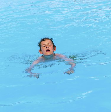 Havuzda yüzen çocuk.