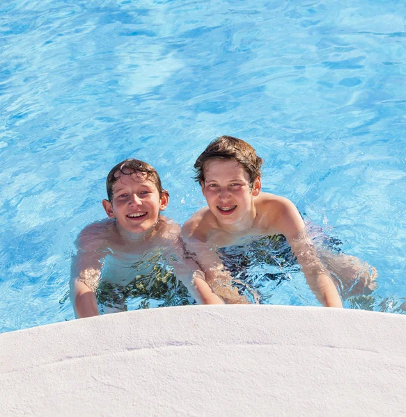 Meninos bonitos se divertir na piscina — Fotografia de Stock