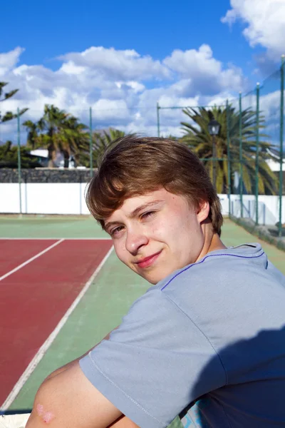 야외 테니스 코트에서 스마트 웃는 소년 — 스톡 사진