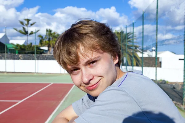 智能微笑的男孩在室外网球场 — 图库照片