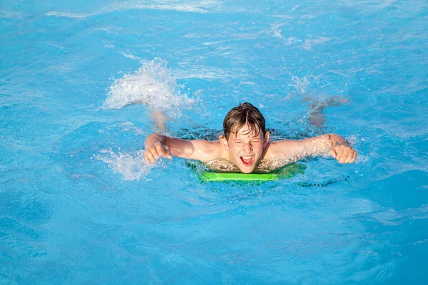 Boy has fun on the surfboard in the pool — Stock Photo, Image