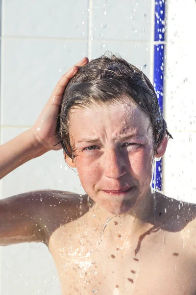 Хлопчик розважається в душі басейну — стокове фото