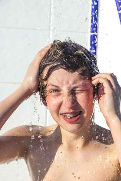 Pojken har kul med pool dusch — Stockfoto