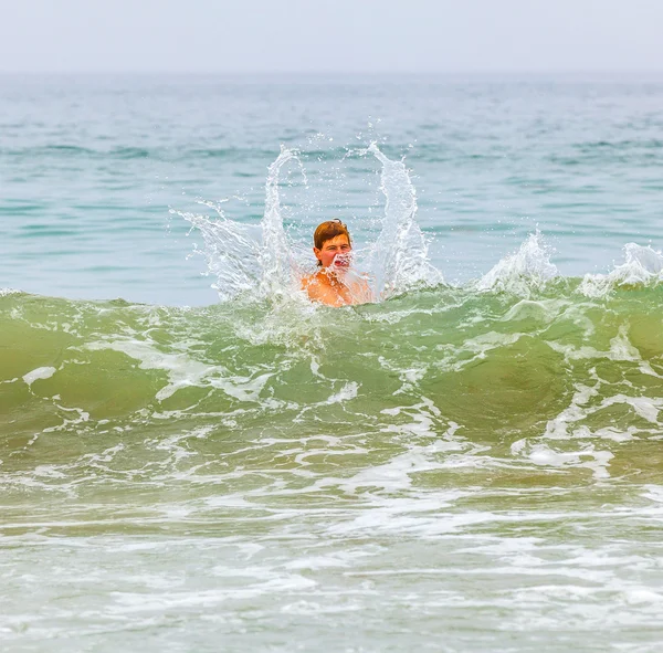 Çocuk eğlenceli dalgalar halinde vardır. — Stok fotoğraf