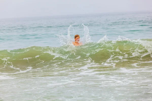 Chlapec má zábavu ve vlnách — Stock fotografie