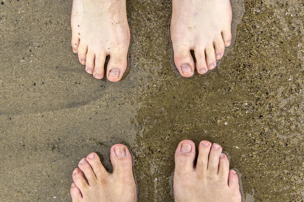 Nohy otce a syna na pláži — Stock fotografie