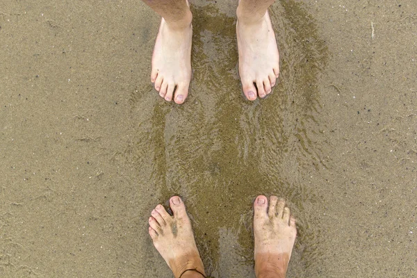 Ноги отца и сына на пляже — стоковое фото