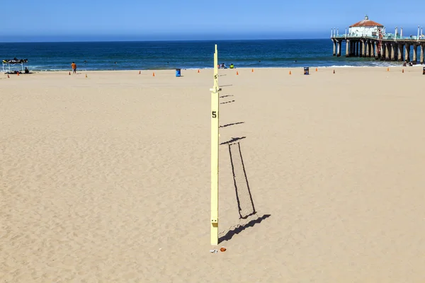 Волейбольное поле на пляже с причалом на заднем плане — стоковое фото