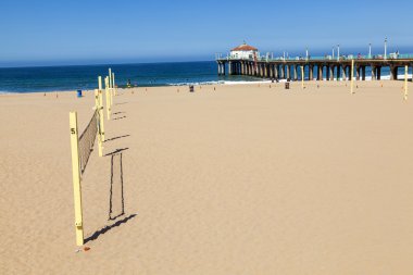 Volleyball field at the beach with the pier in background clipart