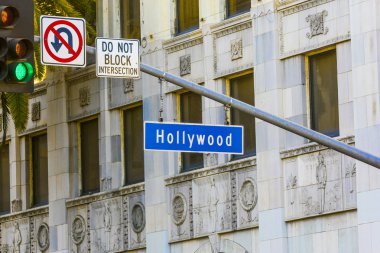 Hollywood Blvd street sign with tall palm trees. clipart