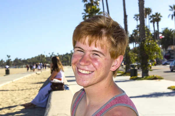 ビーチでポーズ魅力的な少年の笑顔 — ストック写真