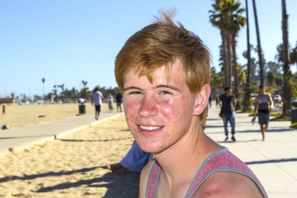 Usmívající se představuje atraktivní kluk na pláži — Stock fotografie