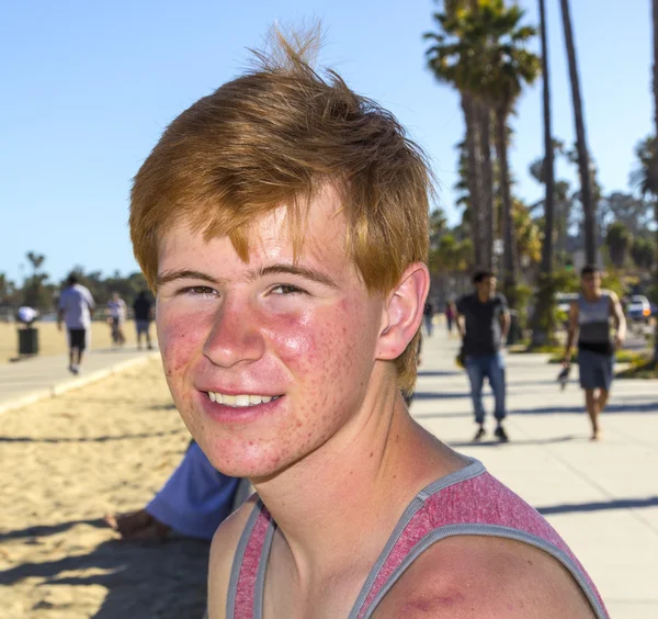 Uśmiechający się atrakcyjny chłopiec pozuje na plaży — Zdjęcie stockowe