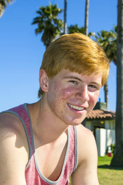 Aantrekkelijke jongen op de strandpromenade glimlachen — Stockfoto