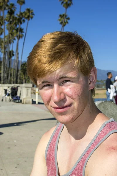 Aantrekkelijke jongen op de strandpromenade glimlachen — Stockfoto