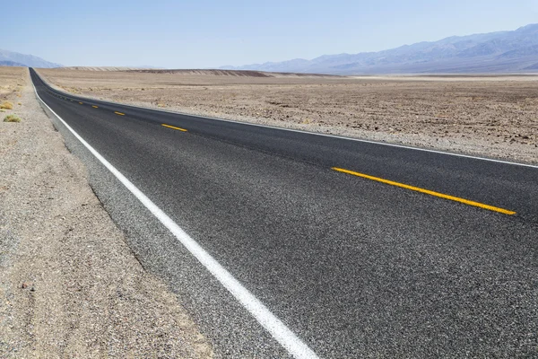 Death Valley road straight across the desert to the mountains in — Stock Photo, Image