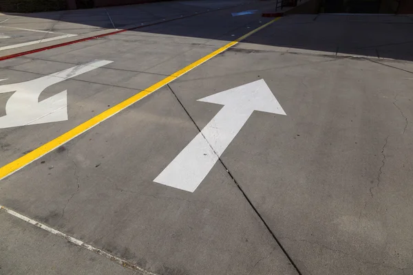 Setas e linhas no asfalto para indicar a direção do dri — Fotografia de Stock