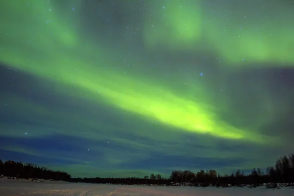 Северное сияние (Aurora borealis) над снежным пейзажем . — стоковое фото