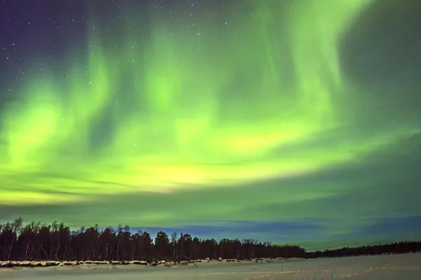 Северное сияние (Aurora borealis) над снежным пейзажем . — стоковое фото