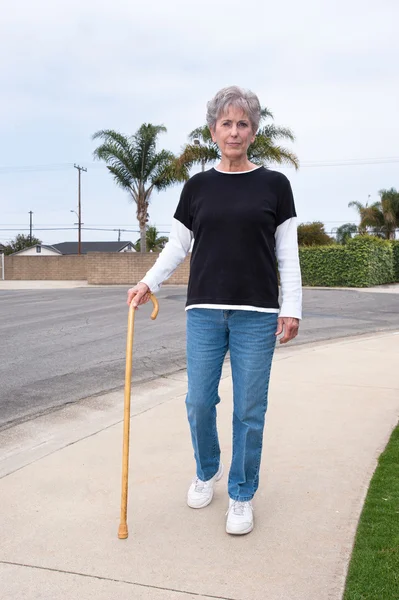 Kvinnan promenader med käpp — Stockfoto