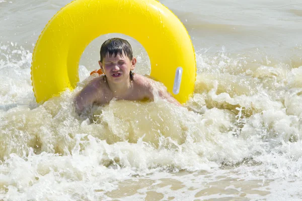Het kind baadt in een zee van gele rubber cirkel — Stockfoto