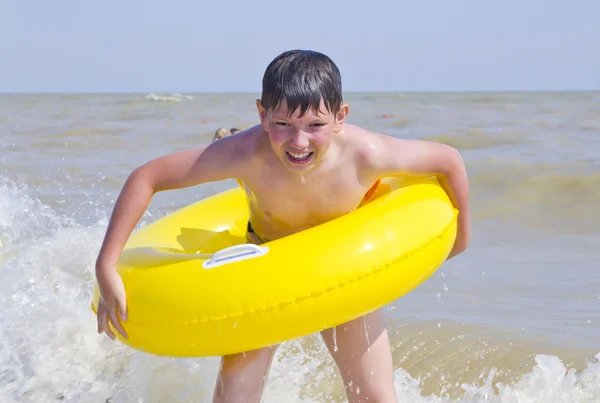 Il bambino è bagnato in un mare di cerchio di gomma giallo — Foto Stock