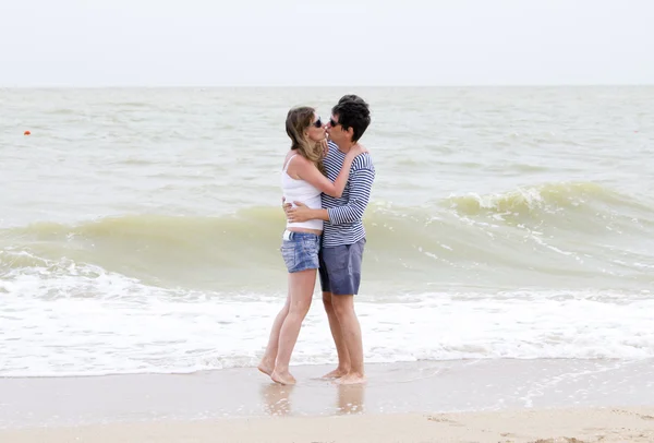 Счастливая пара наслаждается вместе на пляже — стоковое фото