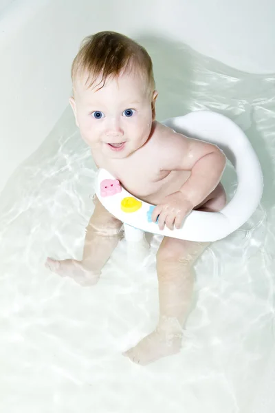 Bébé aux yeux bleus nageant dans le bain — Photo