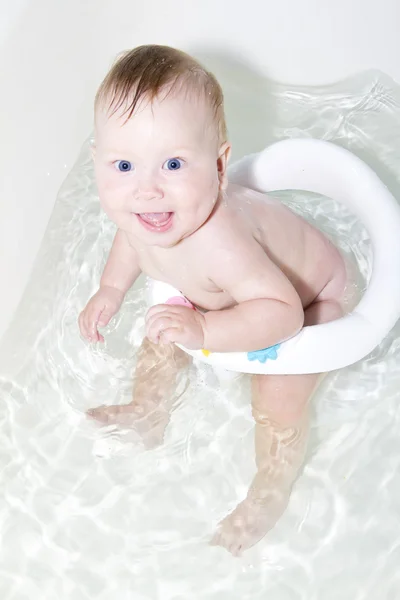 Blauwogige baby zwemmen in het bad — Stockfoto