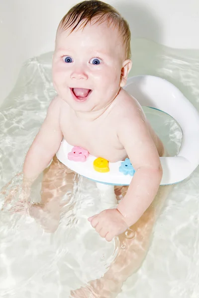 Blå-eyed baby simning i badet — Stockfoto