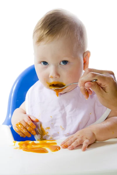 Uma jovem criança de olhos azuis alimentando purê de abóbora — Fotografia de Stock