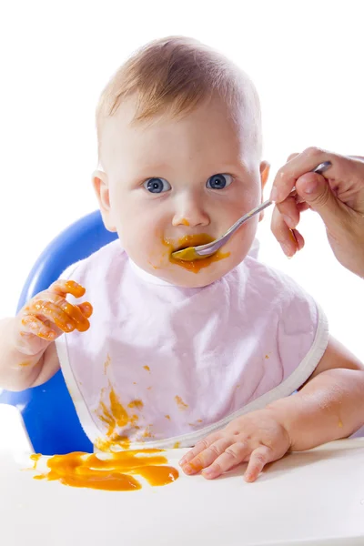 Ein junges blauäugiges Kind füttert Kürbispüree — Stockfoto