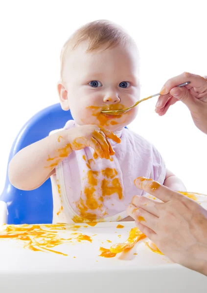 Ein junges blauäugiges Kind füttert Kürbispüree — Stockfoto