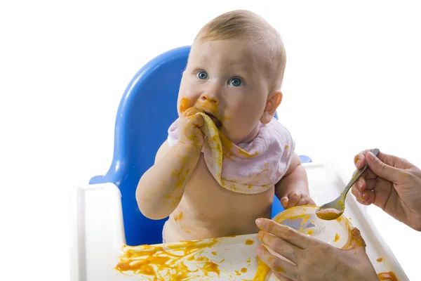 Nuori sinisilmäinen lapsi ruokkii kurpitsan sose — kuvapankkivalokuva