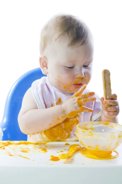 Молодой голубоглазый ребенок кормит тыквенное пюре — стоковое фото