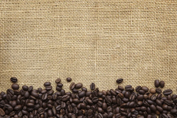 Frijoles de café frontera sobre arpillera — Foto de Stock