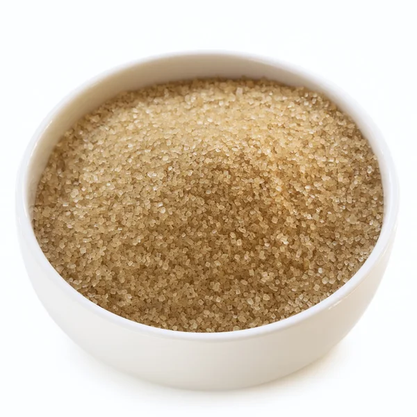 Miska cukru surowego przez biały — Zdjęcie stockowe