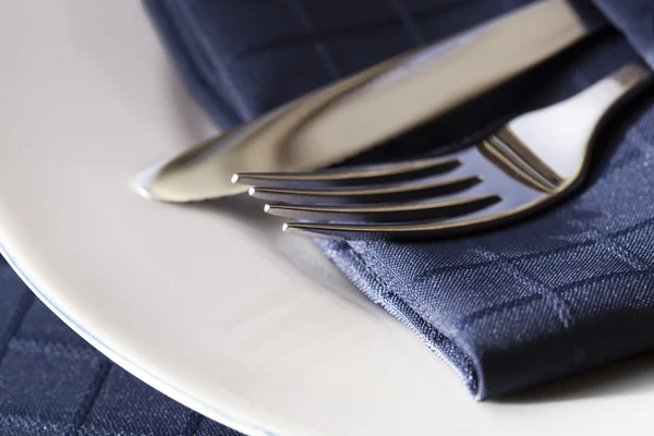A kék szalvéta fehér tányéron evőeszközök — Stock Fotó