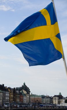 İsveç bayrağı sallayarak Stokholm kent binalar üzerinde