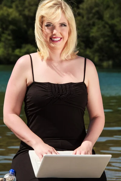 湖の上のラップトップを持つ若い女 — ストック写真